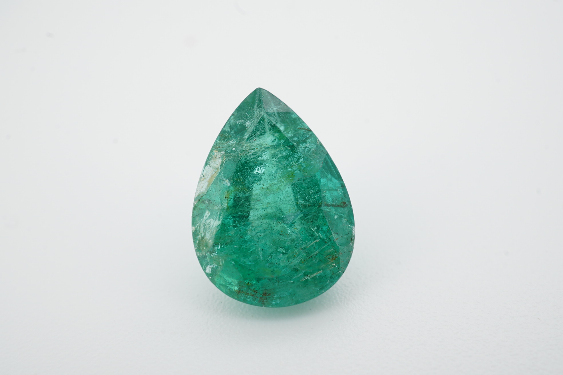 An unmounted pear cut emerald, weighing 6.32ct. Condition - poor to fair